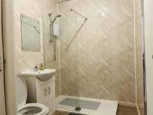 a bathroom with a shower with a toilet and a sink at Cosy Flat - Over Arch in Oswaldtwistle +14 photos