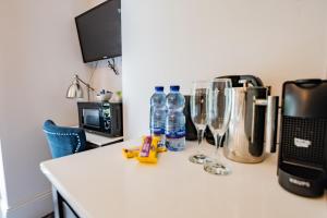 a kitchen counter with bottles of water and wine glasses at Charming Howth Marina Retreat in Dublin