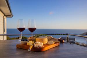 a tray of food and two glasses of wine on a table at Dolphin Dream in Herolds Bay +22 photos