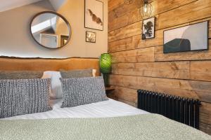 a bedroom with a wooden wall with a bed and a mirror at Windermere Central Hotel - Central Lake District Hotel in Windermere - Ridgestone in Windermere +55 photos