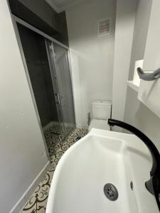 a white bathroom with a shower and a sink at Marin konaklama in Pendik