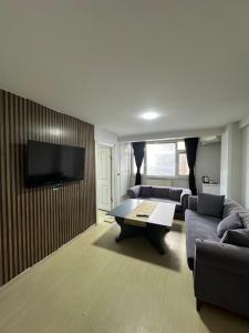 a living room with a couch and a flat screen tv at Marin konaklama in Pendik