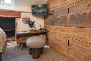 a room with a wooden wall with a stool and a desk at Windermere Central Hotel - Central Lake District Hotel in Windermere - Ridgestone in Windermere