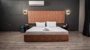 a bedroom with a large bed with a large headboard at We Nirvana Otel in Mezitli