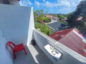 a red chair sitting on the ledge of a balcony at I am Backpacker Hostel in Sabang