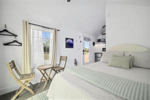 a bedroom with a bed and two chairs and a table at Twilight Ranch Tiny Homes - pet friendly & hill country views in Fredericksburg