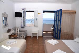 a room with two beds and a view of the ocean at Anna Rooms Kythnos in Kanala