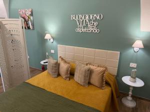 a bedroom with a bed with a yellow blanket and pillows at Pepe 25 in Ruvo di Puglia