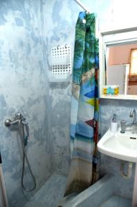 a bathroom with a shower curtain and a sink at Anna Rooms Kythnos in Kanala