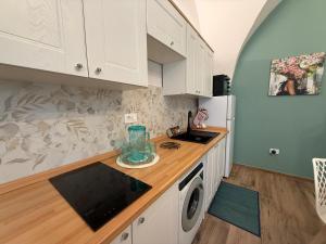 a kitchen with white cabinets and a washer at Pepe 25 in Ruvo di Puglia +2 photos