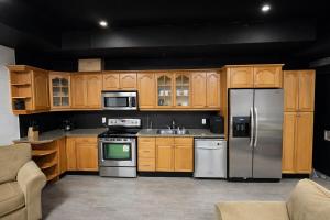 a kitchen with wooden cabinets and stainless steel appliances at Private Suite, King Bed, Big Screen Sleeps 4 in Hamilton