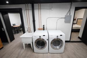 a washer and dryer in a room with a table at Private Suite, King Bed, Big Screen Sleeps 4 in Hamilton