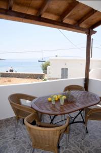 a table and chairs on a patio with a view of the ocean at Anna Rooms Kythnos in Kanala