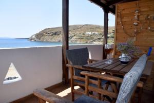 a table and chairs on a balcony with a view of the ocean at Anna Rooms Kythnos in Kanala