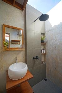 a bathroom with a white sink and a shower at Pam's Cabin Batukaras in Batukaras