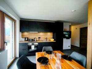 a kitchen with a wooden table with chairs and a dining room at SiLENA Dolomites in Laion