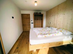 a large bed in a room with wooden floors at SiLENA Dolomites in Laion