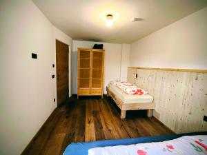 a bedroom with two beds and wooden floors at SiLENA Dolomites in Laion +17 photos