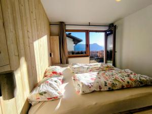 a bedroom with two beds and a large window at SiLENA Dolomites in Laion