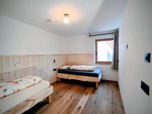 a bedroom with two beds and a window at SiLENA Dolomites in Laion