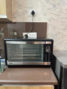 a microwave sitting on a counter in a kitchen at Mansion Grey Studio in Ghaziabad +12 photos