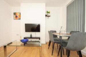 a dining room with a glass table and chairs at Modern 4 Bedroom House Sleeps 10 Free Parking Liverpool in Litherland