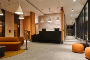 an office lobby with orange chairs and a reception desk at WorldHotels Guadalajara Zona Andares in Guadalajara +108 photos