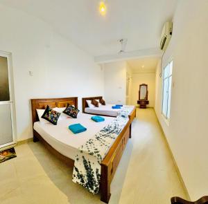 two beds in a room with two beds sidx sidx sidx sidx at Ayomal Beach Paradise in Galle