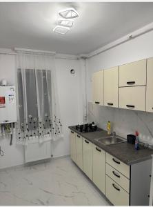 a kitchen with a sink and a counter top at Atlantis Suites Bragadiru Bucuresti Parcare gratuita Self checkin in Bragadiru