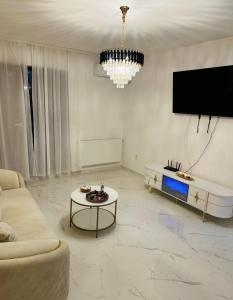 a living room with a couch and a table at Atlantis Suites Bragadiru Bucuresti Parcare gratuita Self checkin in Bragadiru