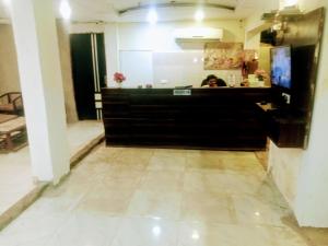 a woman sitting at a counter in a room at Hotel Alpine in Chandīgarh