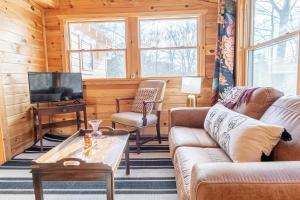 a living room with a couch and a tv at Northern Acres in Lake George