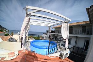 a pergola over a swimming pool on a balcony at Studio Gio in Zakynthos City in Zakynthos