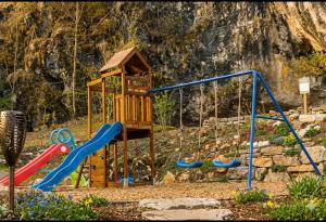 a playground with a slide and a swing set at Refugiul Apusenilor in Scărişoara