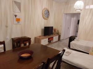 a living room with a table and a tv and a couch at Fiosal Apartments 1 in Skiathos