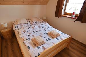 a bed with towels on it in a bedroom at Chata Relax 1 in Pribylina