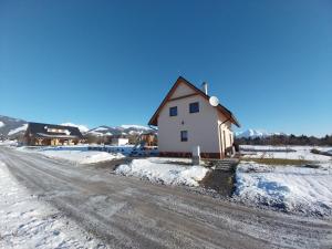 a house on the side of a snow covered road at Chata Relax 1 in Pribylina