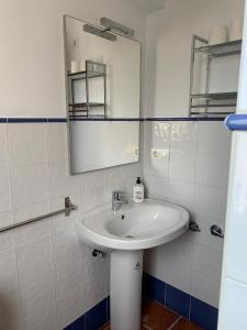 a white bathroom with a sink and a mirror at Hostel Los Guajares in Guájar-Faragüit +39 photos