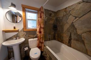 a bathroom with a sink and a toilet and a tub at Shaver Lake Village Hotel in Shaver Lake +82 photos