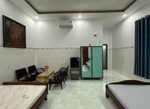 a room with two beds and a table and chairs at Khách Sạn Vinhomes Huỳnh in Phú Nhuận