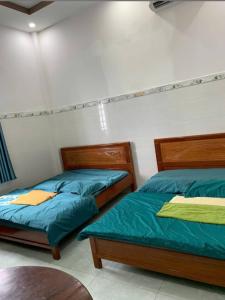 two beds sitting next to each other in a bedroom at Khách Sạn Vinhomes Huỳnh in Phú Nhuận