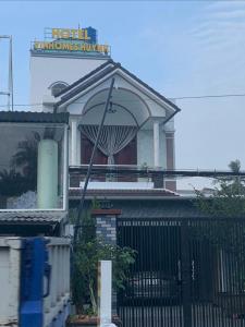 a sign on top of a house with a fence at Khách Sạn Vinhomes Huỳnh in Phú Nhuận