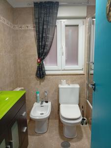 a bathroom with a toilet and a sink at Ka'Luzy in Santa Ana