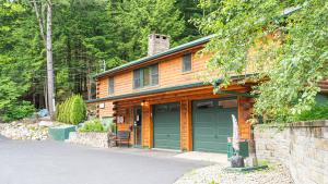a wooden house with a garage in front of it at Northern Acres in Lake George