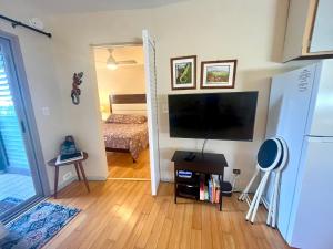 a living room with a flat screen tv and a bedroom at Beachfront 1 Bedroom Condo with Private Beach, Pool, Hot Tub in Pahala