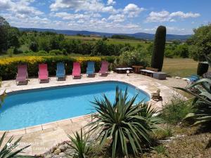 a swimming pool in a yard with chairs at La maison de Nazig in Pertuis