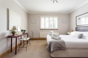 a bedroom with a large white bed and a desk at Sandy Shores - Moments from Blue Flag Sandbanks Beach in Poole