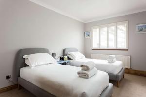 a room with two beds and a window at Sandy Shores - Moments from Blue Flag Sandbanks Beach in Poole