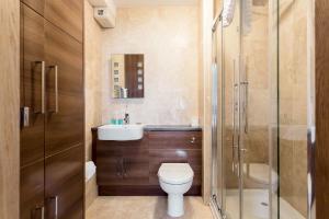 a bathroom with a toilet and a sink and a shower at Sandy Shores - Moments from Blue Flag Sandbanks Beach in Poole +24 photos
