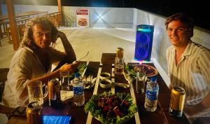two men sitting at a table with a plate of food at Rainforest Jungle Chill Singharaja in Deniyaya +35 photos
